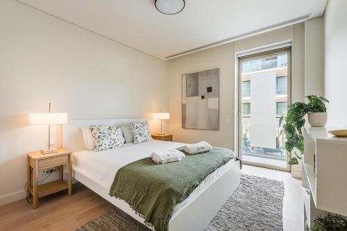 a white bedroom with a bed and a window at GuestReady - Bright & Inviting Stay in Vila Nova de Gaia