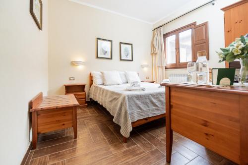 a small bedroom with a bed and a table at Il Casale Colle San Pietro in San Pietro