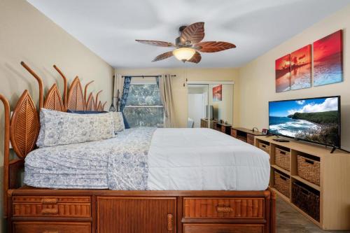 a bedroom with a bed and a flat screen tv at Big Island Fairway Terrace A-202 by Coldwell Banker Island Vacations in Waikoloa Village
