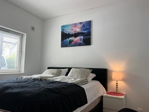 a bedroom with a bed and a picture on the wall at Cozy double bed room near to Eslöv station in Eslöv
