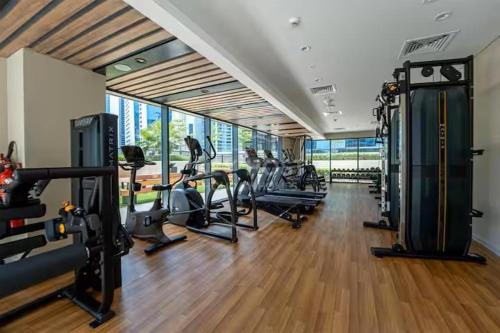 una palestra con diversi tapis roulant e macchine in una stanza di Canal Luxe Burj 1BR Sleeps 4 with Pool and Gym a Dubai