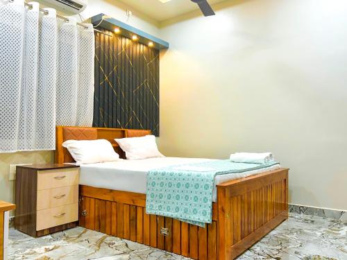 a bedroom with a bed with a blue blanket on it at Fraydel Homestay in Honāvar