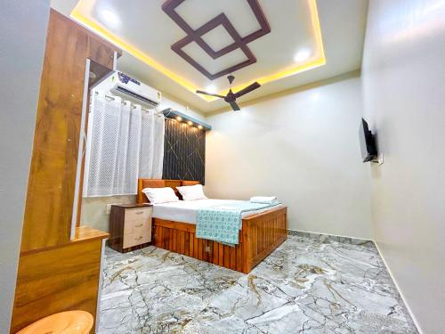 a bedroom with a bed with a marble floor at Fraydel Homestay in Honāvar