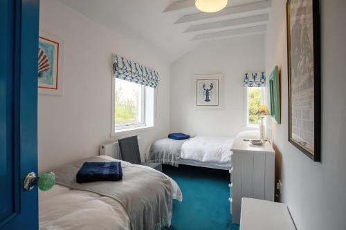 a bedroom with two beds and a window at Taigh Phinc in Paible