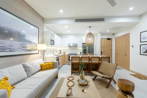 a living room with a white couch and a table at Pura Vida Peaceful Condo At Become Nosara in Nicoya