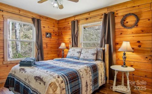 a bedroom with a bed and two windows at Fox Creek Cabin 3: Creekside Cabin in the Smoky Mountains! in Bryson City
