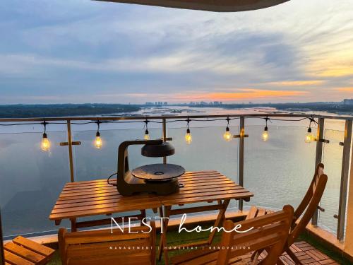 a table and chairs on a balcony with a view of the water at Country Garden Seaview Suite by Nest Home at Danga Bay in Johor Bahru