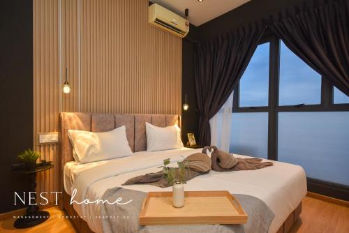 a bedroom with a bed with a table and a window at Country Garden Seaview Suite by Nest Home at Danga Bay in Johor Bahru
