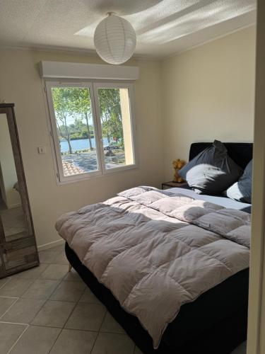 un grand lit dans une chambre avec une fenêtre dans l'établissement Casa Bella, à Agde