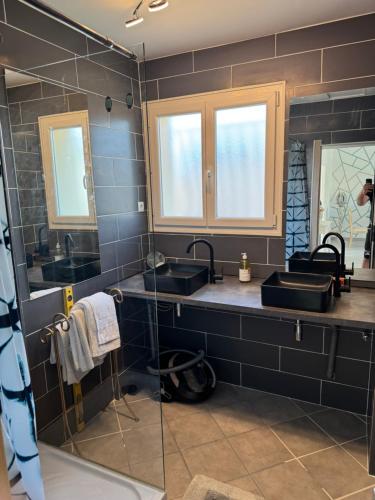 une salle de bain avec deux lavabos et deux miroirs dans l'établissement Casa Bella, à Agde