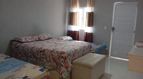 a small bedroom with a bed and a window at Casa da Lu - Aconchego Baiano in Salvador