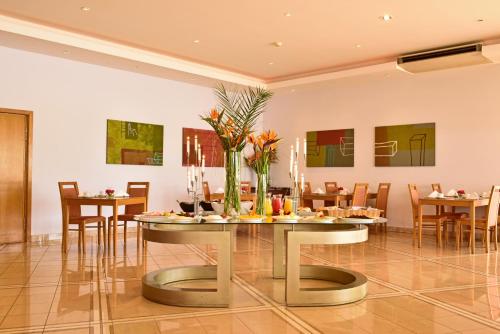 Un comedor con una mesa con flores. en Pestana Alvor Park Suites Hotel, en Alvor