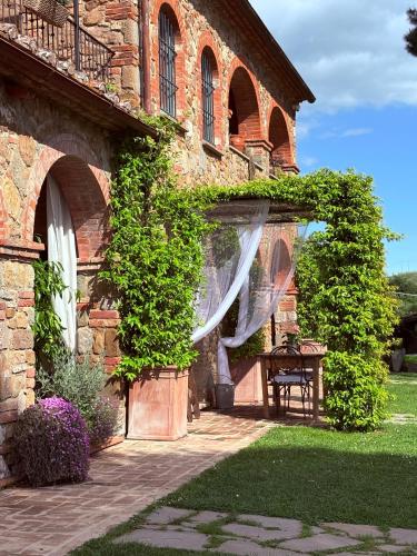 an entrance to a brick building with a white curtain at CASA VASARI Holiday Suites TUSCANY in Lucignano