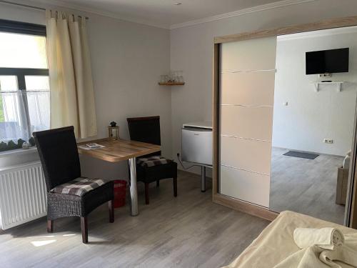 a room with a desk and a table and a table and chairs at Pension Weiß in Zinnowitz