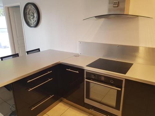 une cuisine avec une cuisinière et un comptoir dans l'établissement Duplex cosy - 3 chambres avec garage, balcon et clim, à Lyon