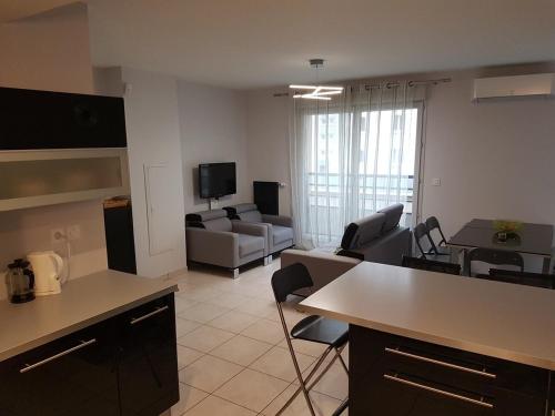 un salon avec une cuisine et un salon avec un canapé dans l'établissement Duplex cosy - 3 chambres avec garage, balcon et clim, à Lyon