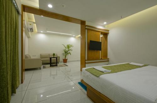 a hotel room with a bed and a living room at HOTEL AURELLIA in Sarkhej