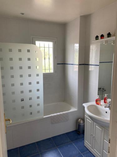 une salle de bain blanche avec une baignoire et un lavabo dans l'établissement Le Mas des Oliviers, à Opio