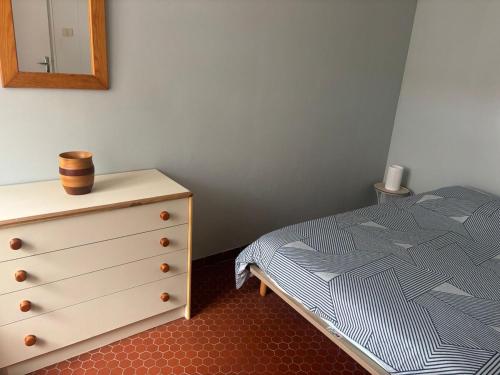 une chambre avec un lit et une commode avec un miroir dans l'établissement Pavillon cosy 6 pers Patio privé et plage à pied, à Port-la-Nouvelle