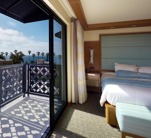 a hotel room with a bed and a balcony at Cormorant Boutique Hotel in San Diego