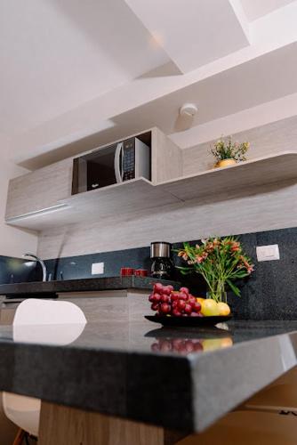 a kitchen counter with a bowl of fruit on it at Kasa Hotel & Suites in Irapuato