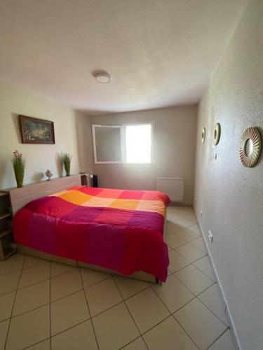 - une chambre avec un lit et une couverture colorée dans l'établissement Beautiful apartment close to the beach, à Toulon