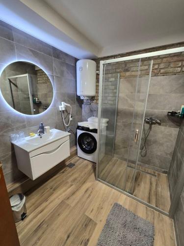 a bathroom with a shower and a sink and a mirror at Moja Mona in Subotica
