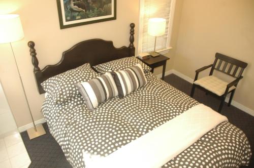 a bedroom with a large bed with pillows and a chair at Cambie Lodge in Vancouver