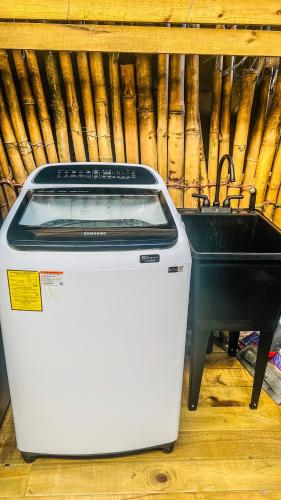 a washing machine sitting next to a sink at Suites Bocas del Toro in Carenero