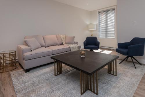 a living room with a couch and a table at La Maison Kent - Par Aneyro in Quebec City