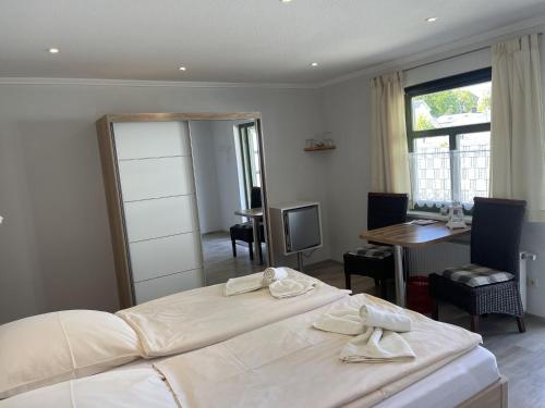 a bedroom with a large white bed and a desk at Pension Weiß in Zinnowitz