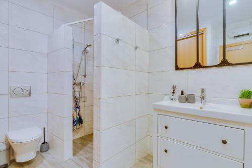 a white bathroom with a sink and a shower at Patio Suite - by Enjoy your stay in Olhão