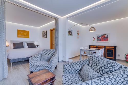 a bedroom with a bed and a couch and chairs at Patio Suite - by Enjoy your stay in Olhão