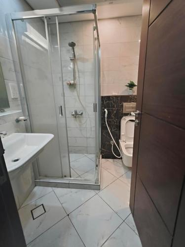 a bathroom with a shower and a toilet at B&B Homes in Abu Dhabi