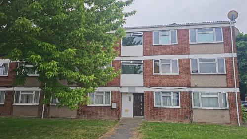 a brick building with a tree in front of it at Langley One Bedroom Flat in Langley Station