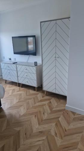 a room with a television and a wooden floor at Langley One Bedroom Flat in Langley Station