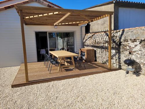 a wooden deck with a table and chairs on a house at Les écuries in Secondigny