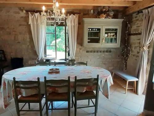 une salle à manger avec une table et des chaises blanches dans l'établissement Charmante maisonnette en pierre près d'Épinal - FR-1-589-804, à Uzemain