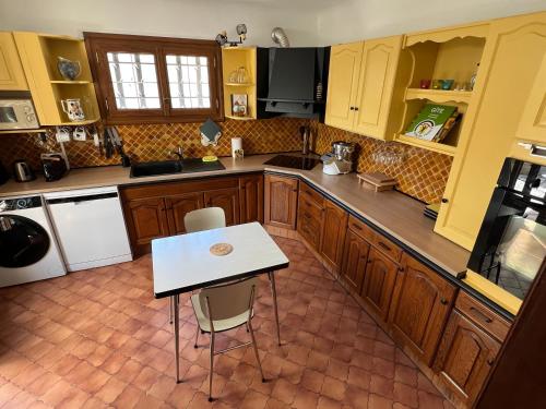 une cuisine avec une table et une table blanche dans l'établissement Maison provençale sur la colline, à Caumont-sur-Durance