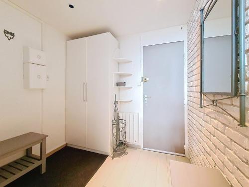 Cette chambre blanche dispose d'une porte et d'un mur en briques. dans l'établissement Appartement spacieux aux Menuires, 3 pièces, 8 pers, balcon Sud/Ouest, ascenseur - FR-1-344-1170, aux Menuires