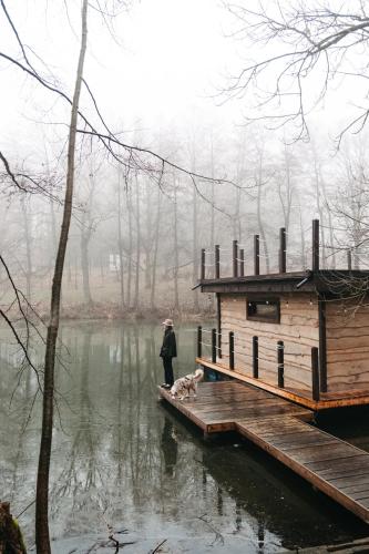 a person and a dog standing on a dock at Živili in Smilkov