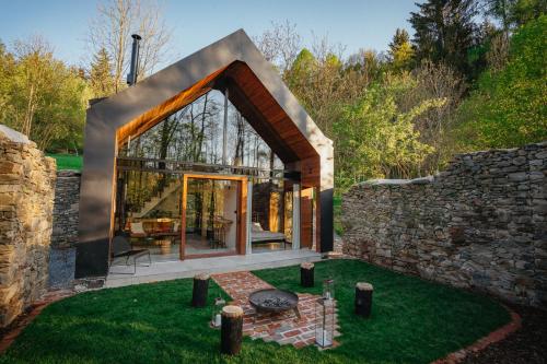 a glass house with a stone wall at Živili in Smilkov