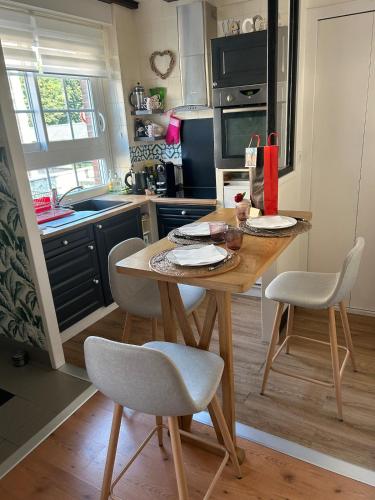 une cuisine avec une table en bois et deux chaises dans l'établissement Studio chic de Sophie plein cœur du centre-ville, à Honfleur