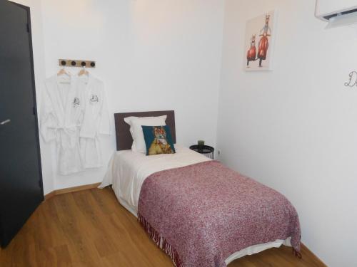 a white bedroom with a bed and a clothes rack at Espace de détente à Colombey avec SPA et jacuzzi - FR-1-611-115 in Colombey-les-deux-Églises