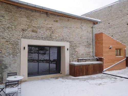 a door to a brick building with snow on the ground at Espace de détente à Colombey avec SPA et jacuzzi - FR-1-611-115 in Colombey-les-deux-Églises