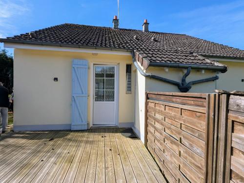 a small house with a door and a wooden fence at Gîte au Bord de la Creuse avec Jardin Privé - FR-1-591-735 in Ceaulmont