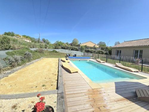une piscine avec une terrasse en bois à côté d'une maison dans l'établissement Maison périgourdine avec piscine privative, internet et animaux acceptés - FR-1-616-476, à Sainte-Sabine