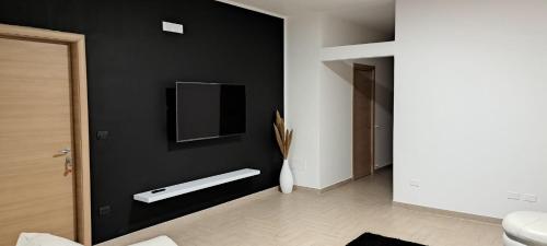 un bagno con una parete nera con un water e una tv di Casa Vacanza Martano a Martano