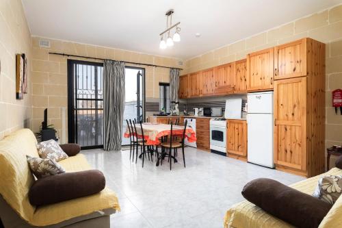 a kitchen and living room with a table and chairs at 2BD Spacious Apartment with Front Terrace and Country Views - Gozo Island in Qala