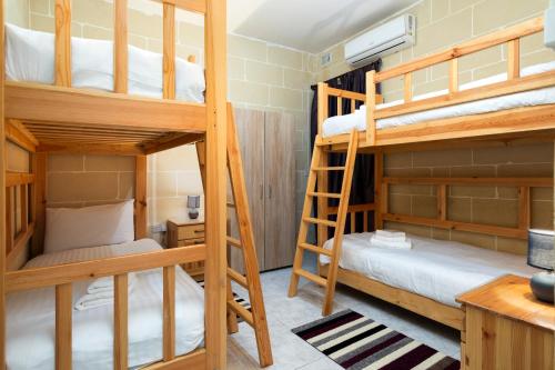 a room with bunk beds in a hostel at 2BD Spacious Apartment with Front Terrace and Country Views - Gozo Island in Qala